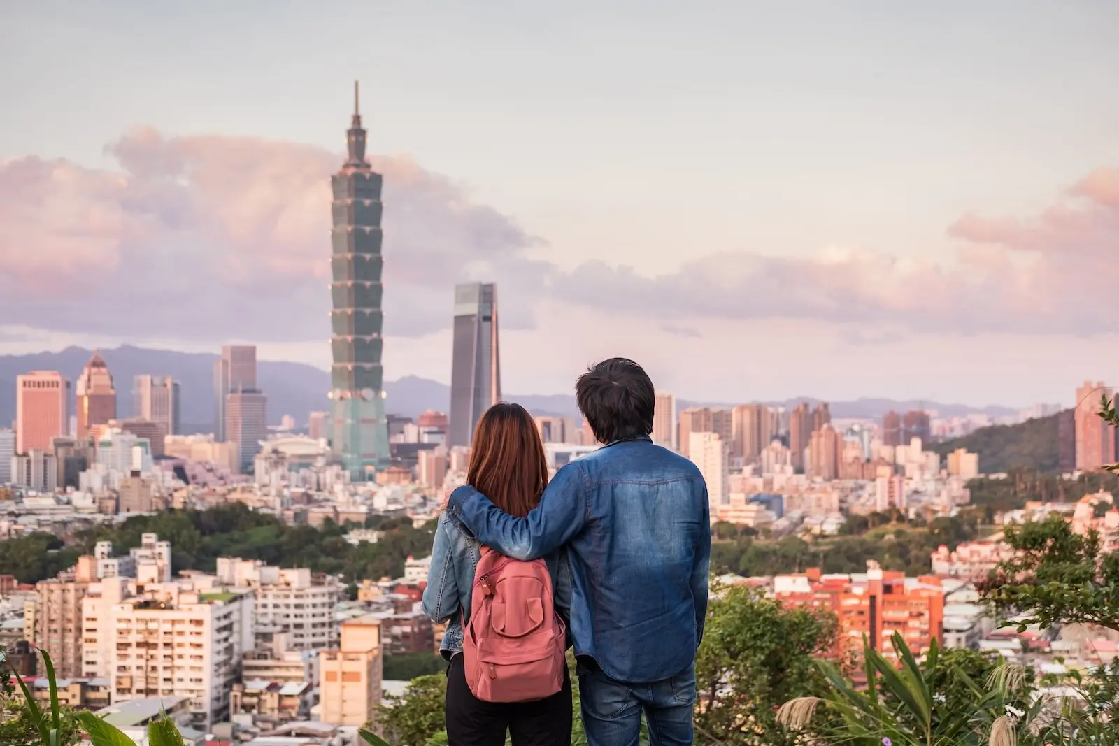 Paar bewundert die Skyline von Taipei 101 von einem Hügel bei Sonnenuntergang